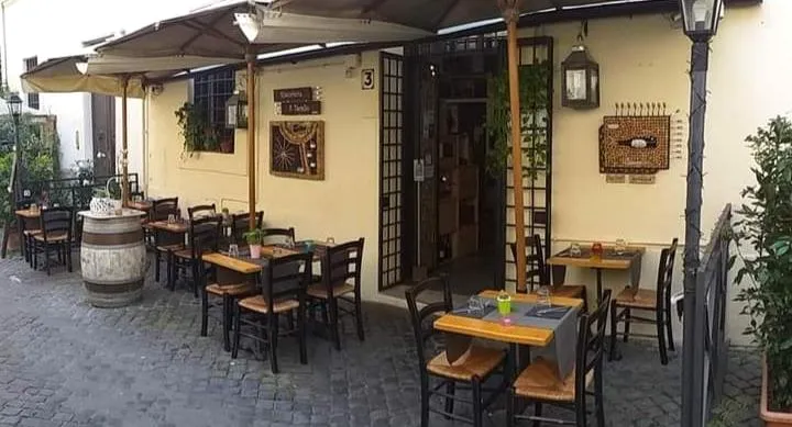 L'ingresso al numero 3 di Vicolo della Scala, con le lanterne e i tavoli fuori